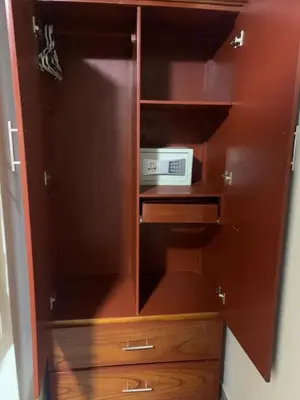 a wooden cabinet with a microwave in it at A-Hope Suite Hotel in Huancayo