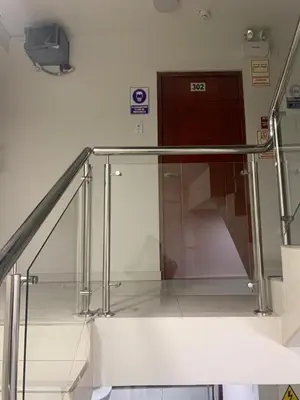 a stair case in a building with a glass railing at A-Hope Suite Hotel in Huancayo