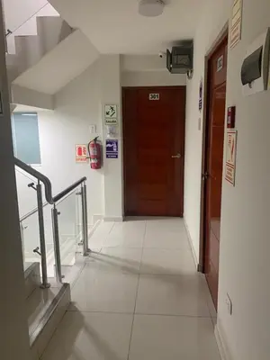 a hallway with a brown door in a building at A-Hope Suite Hotel in Huancayo