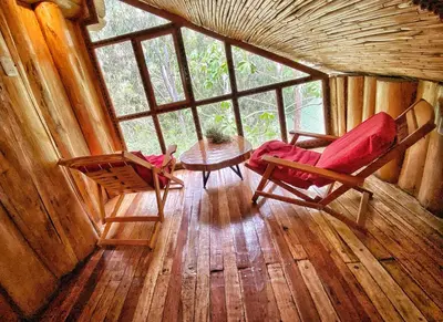 a room with two chairs and a table in a cabin at Eco Quechua Lodge in Santa Teresa