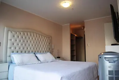 a bedroom with a large white bed with a large headboard at GL Apts, rent Upper Pardo Miraflores - Suite 1 Hab in Lima