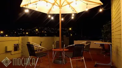 a table and chairs under an umbrella at night at Hostal Residencial Mochica in Lima