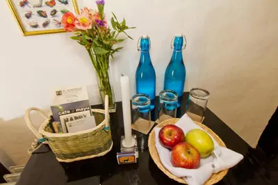 a table with a basket of fruit and blue bottles at El Albergue Ollantaytambo in Ollantaytambo
