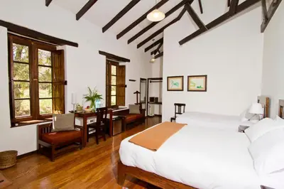 a bedroom with a bed and a desk in a room at El Albergue Ollantaytambo in Ollantaytambo