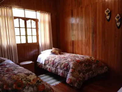 a bedroom with a bed and a window in it at La Cabaña de Noa in Oxapampa