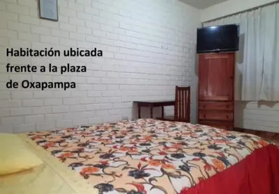 a bedroom with a bed with a floral blanket at La Cabaña de Noa in Oxapampa
