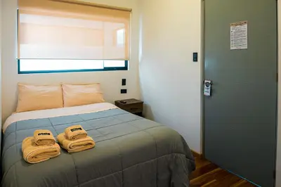 a bedroom with a bed with two towels on it at Net House Cusco in Cusco