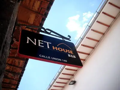 a net house sign hanging from the side of a building at Net House Cusco in Cusco