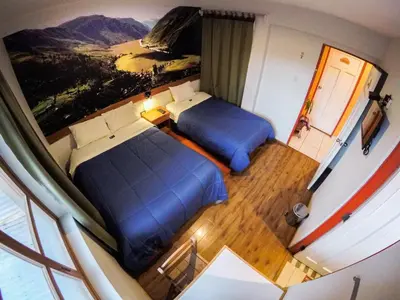 two beds in a small room with a view at Net House Cusco in Cusco