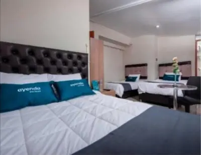 a large bedroom with two beds and a table at Hotel Luna de Oro Cusco in Cusco