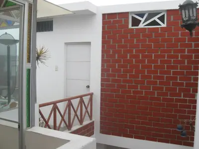 a red brick wall next to a door at Posada Peregrinus in Lima