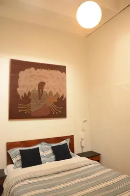 a bedroom with a bed with a painting on the wall at Flying Dog Lima B&B in Lima