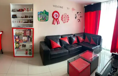 a living room with a black leather couch and red pillows at Peruvian Apartment in Lima