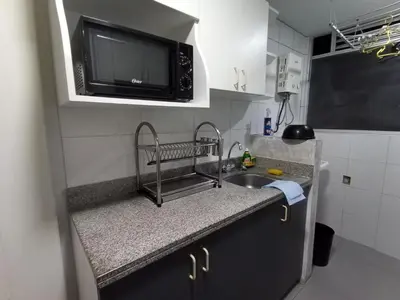 a small kitchen with a sink and a microwave at Peruvian Apartment in Lima