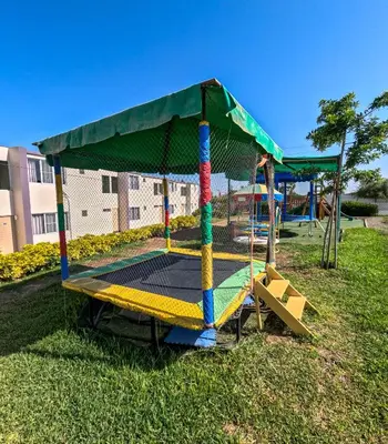 a playground with a swing set in a park at El Paraíso Eco Resort in Pisco
