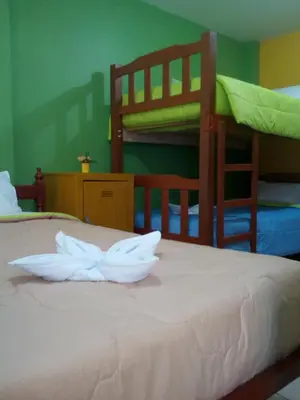 a bedroom with two bunk beds with white sheets at Sunset Hostel Airport in Lima