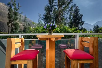 a table with two chairs and a vase of flowers at Hacienda del Valle Sagrado in Urubamba