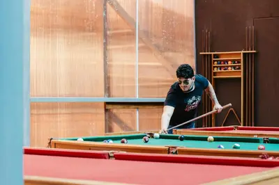 a man playing pool with a cue on a pool table at Hacienda del Valle Sagrado in Urubamba