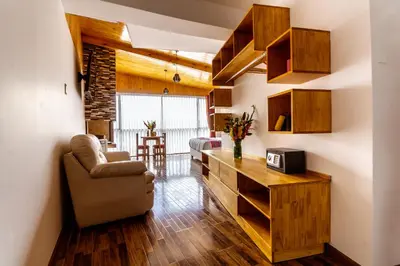 a living room with wooden cabinets and a couch and a table at Hacienda del Valle Sagrado in Urubamba
