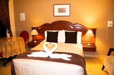 a hotel room with a bed with two swans on it at Solis Dies Hotel in Lima