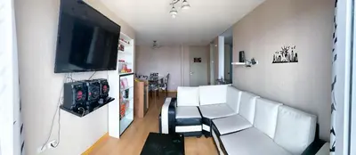 a living room with white chairs and a flat screen tv at Condominio Uptown de 2 dormitorios in Lima
