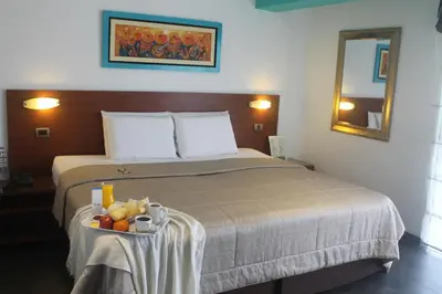 a hotel room with a bed with a tray of fruit on it at Hotel Vila Santa in Lima