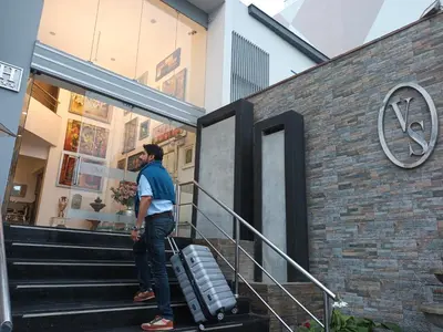 a man standing on the stairs with a suitcase at Hotel Vila Santa in Lima
