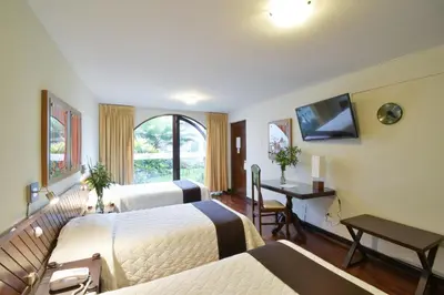 a hotel room with two beds and a desk at Hotel Señorial in Lima