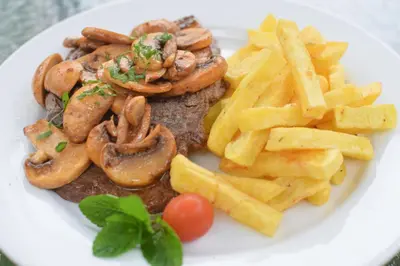a plate of food with steak and french fries at Hotel Señorial in Lima