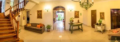 a living room with a couch and a stair case at Hotel Señorial in Lima