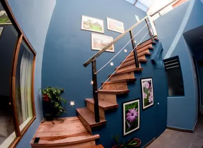 a staircase in a house with blue walls and wooden steps at Cooper Hotel Boutique in Cusco