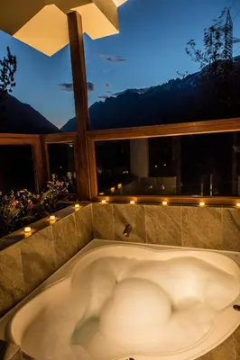 a bath tub in a room with a large window at Del Pilar Ollantaytambo in Ollantaytambo