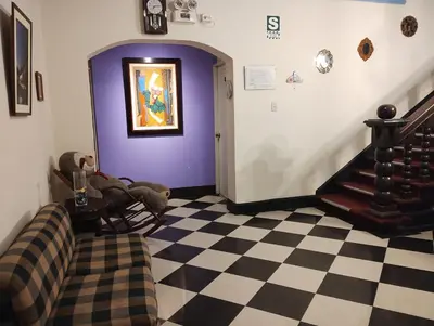 a living room with a checkered floor and purple walls at The Place Miraflores in Lima