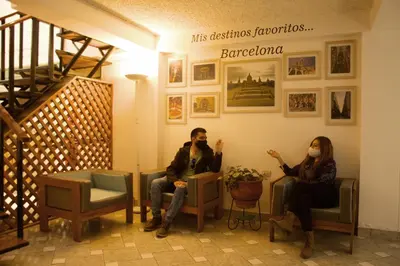 a man and a woman sitting in a waiting room at Los Aticos B&B with Coworking in Cusco