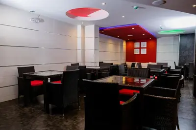 a restaurant with tables and chairs and a red wall at Verona Hotel Baños Turcos in Lima