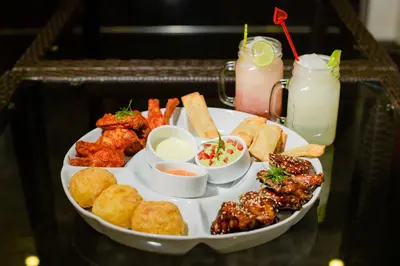 a tray of food with appetizers and drinks on a table at Verona Hotel Baños Turcos in Lima