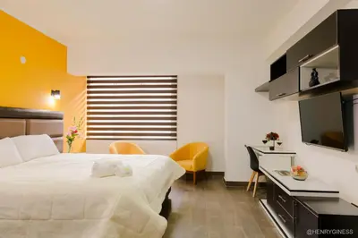 a bedroom with a bed and a desk and a television at Hotel Turin in Tarma