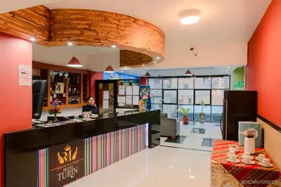 a woman sitting at a counter in a restaurant at Hotel Turin in Tarma