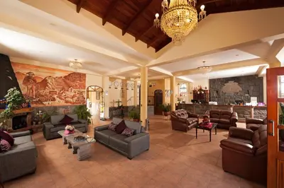 a large living room with couches and a fireplace at Hotel Mabey Urubamba in Urubamba