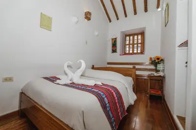 a bedroom with a bed with two white towels on it at Hostal El Grial in Cusco