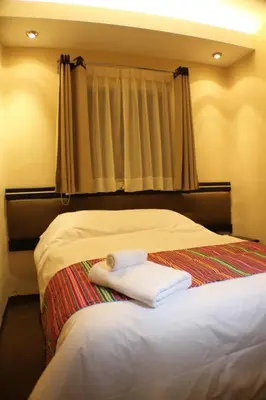 a bedroom with a bed with two towels on it at Tampu Hotel in Cusco