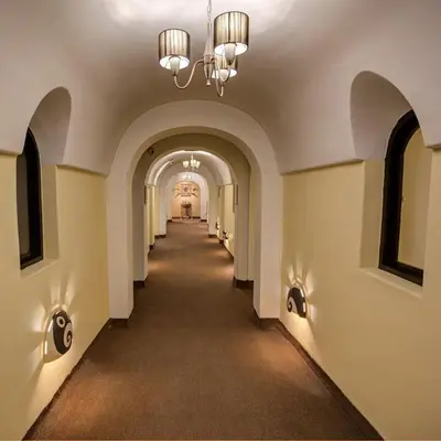 a hallway in a building with a chandelier at Tampu Hotel in Cusco