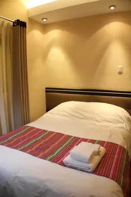 a bed with three folded towels sitting on it at Tampu Hotel in Cusco