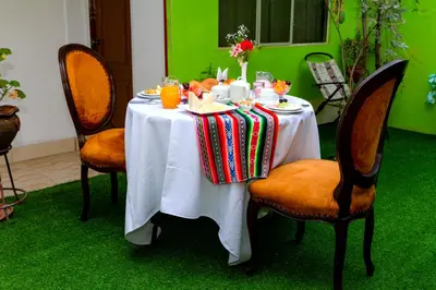 a table with a white table cloth on it with chairs at Hotel Sol del Oriente Cusco in Cusco