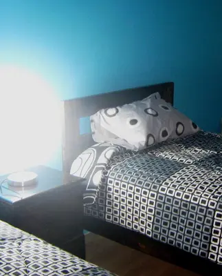 a bedroom with a bed with a pillow and a table at apartamentos Los cedros in Lima