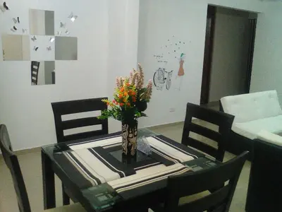 a dining room table with a vase of flowers on it at apartamentos Los cedros in Lima