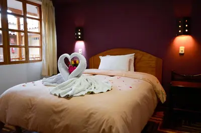 a bed with two swans made to look like hearts at Hostal Qorichaska in Cusco