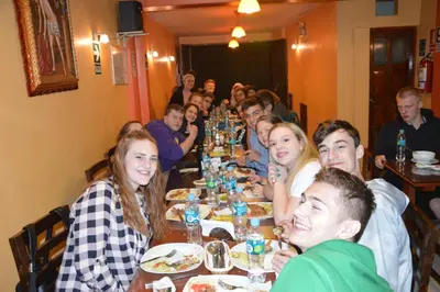a group of people sitting at a long table at Hostal Wasichay in Cusco