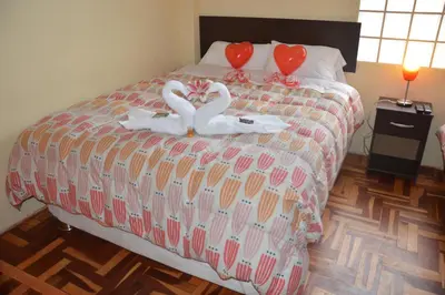 two swans are sitting on top of a bed at Hostal Wasichay in Cusco