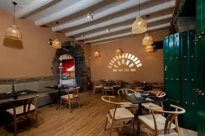 a restaurant with tables and chairs and lights at Hotel Hacienda Sonqori Centro Histórico in Cusco